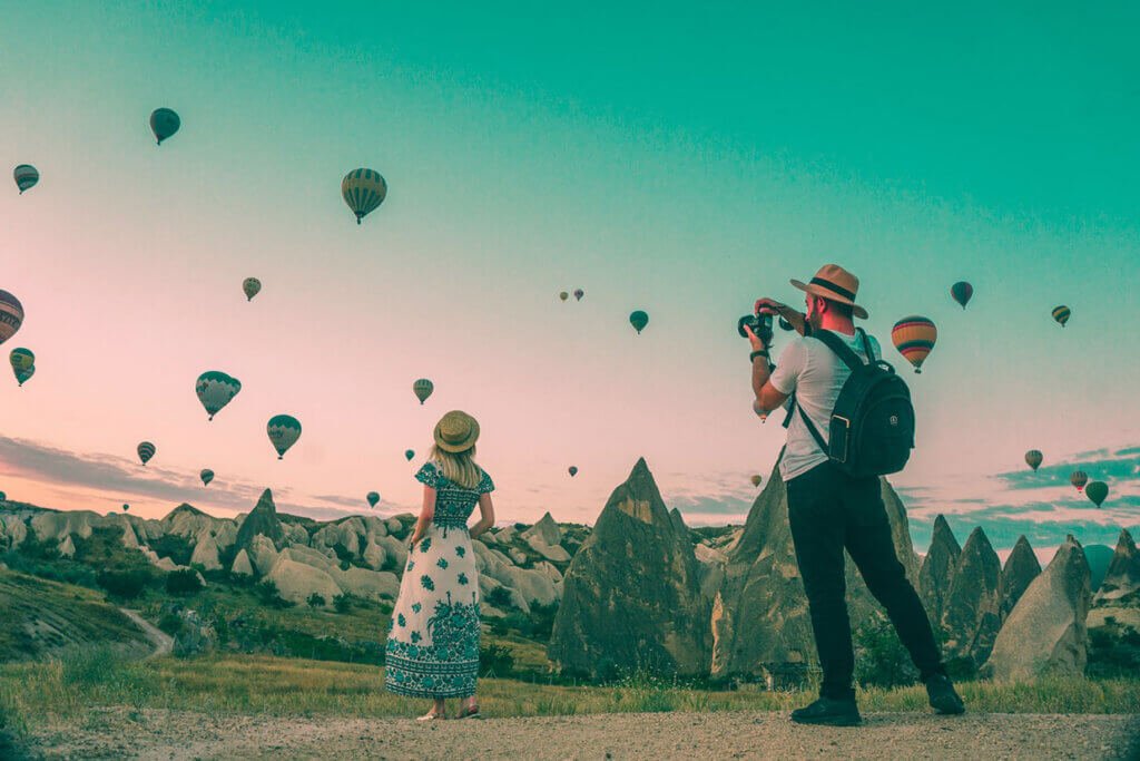 Man taking photo of hot air balloons